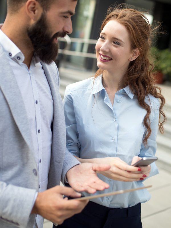 smiling-business-man-and-woman-chatting-outdoor-M5EHGAQ.jpg